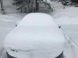 Verschneites Auto an Weihnachten für die Fahrt nach Hause zur Liebsten.