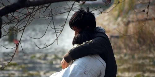 Paar sitzt am See, nachdem sie den Ex zurück bekommen hat.